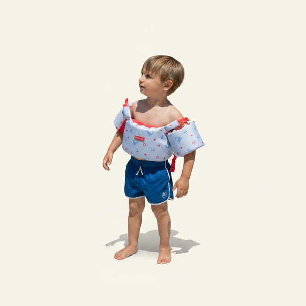 Child wearing a life jacket by a pool