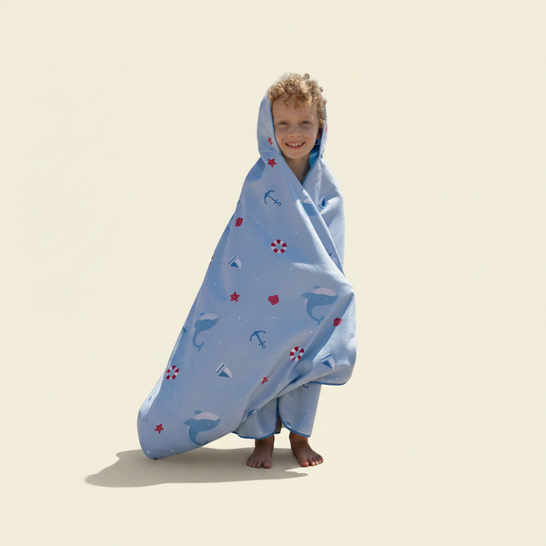 Child wrapped in a patterned towel on a beach