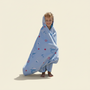 Child wrapped in a patterned towel on a beach