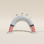 Inflatable arch with checkered pattern on a grassy area with trees and building in the background