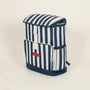 Blue and white striped backpack with a visible brand logo on a beige background